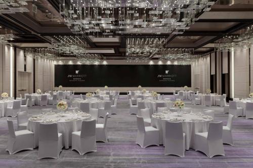 a banquet hall with white tables and chairs and a screen at JW Marriott Marquis Hotel Shanghai Pudong in Shanghai