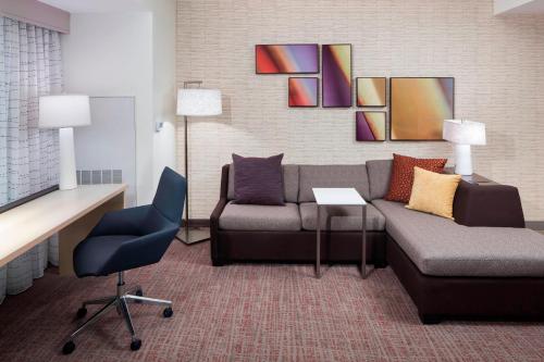 uma sala de estar com um sofá e uma cadeira em Residence Inn by Marriott Near Universal Orlando em Orlando