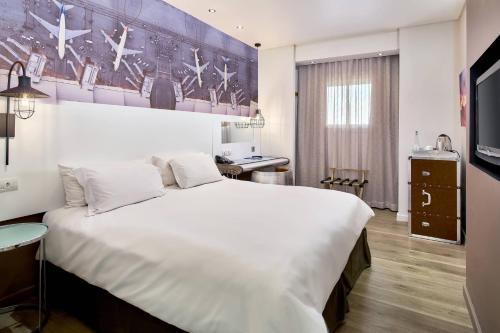 a bedroom with a large white bed and a desk at Protea Hotel by Marriott O R Tambo Airport in Kempton Park