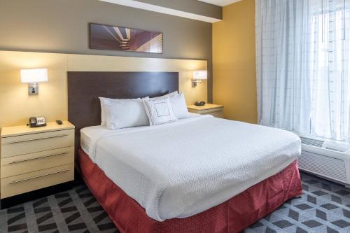 um quarto de hotel com uma cama grande e uma janela em TownePlace Suites Dayton North em Dayton