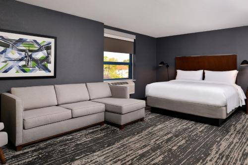 Habitación de hotel con cama y sofá en Four Points by Sheraton Omaha Midtown, en Omaha