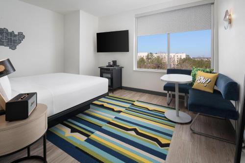 a hotel room with a bed and a table and a chair at Aloft Houston Shenandoah - The Woodlands in Shenandoah