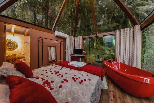 um quarto com uma cama e uma banheira em Pousada Jardim do Buda Piscina e Hidro em Urubici