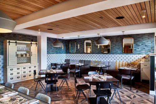 a restaurant with tables and chairs in a room at The Casso, Raleigh, a Tribute Portfolio Hotel in Raleigh