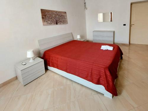 1 dormitorio con cama roja y manta roja en Casa Ortigia, en Siracusa