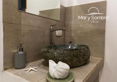 a bathroom with a stone sink and a bath tub at Mar y Sombra Villas in Quepos