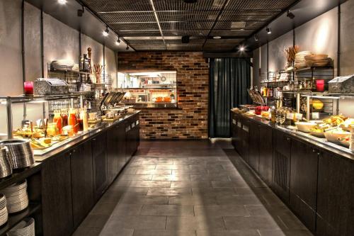 a restaurant with a long line of counters with food at Clarion Collection Hotel Katajanokka in Helsinki