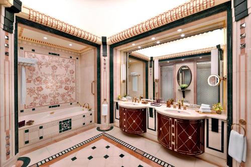 ein Badezimmer mit zwei Waschbecken, einer Badewanne und einem großen Fenster in der Unterkunft The Ritz-Carlton Jeddah in Dschidda