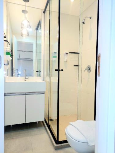 a bathroom with a shower and a toilet and a sink at Apto Stúdio Área Central - 2 pessoas - Crianças Grátis - Colchão com massageador - Próx do Shopping Estação!! in Curitiba