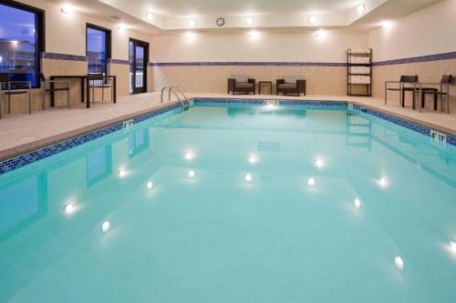a swimming pool in a hotel with blue water at TownePlace Suites by Marriott Sioux Falls South in Sioux Falls
