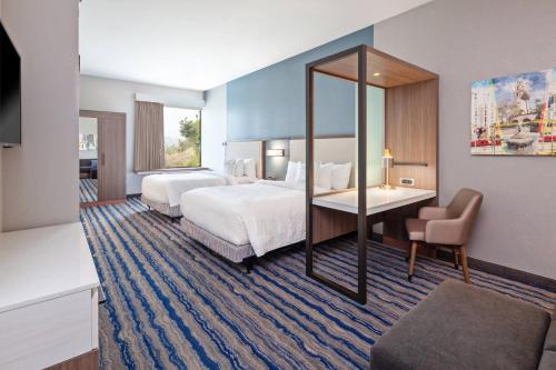 エスコンディードにあるSpringHill Suites by Marriott Escondido Downtownのベッド2台とデスクが備わるホテルルームです。