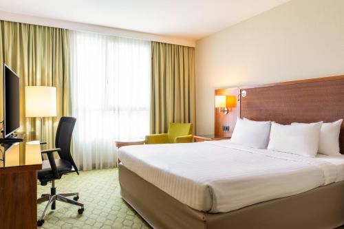 a hotel room with a bed and a desk at Courtyard by Marriott Paris Saint Denis in Saint-Denis