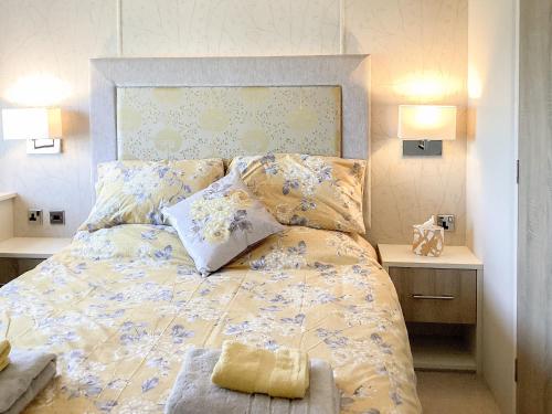 um quarto com uma cama com um edredão amarelo e azul em Ballagan Lodge em Leanach