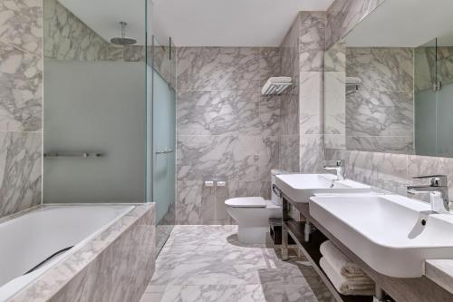 a bathroom with two sinks and a tub and a toilet at Element Kuala Lumpur in Kuala Lumpur