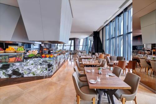 a restaurant with wooden tables and chairs and windows at Element Kuala Lumpur in Kuala Lumpur