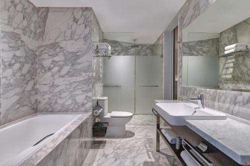 a bathroom with a tub and a sink and a toilet at Element Kuala Lumpur in Kuala Lumpur