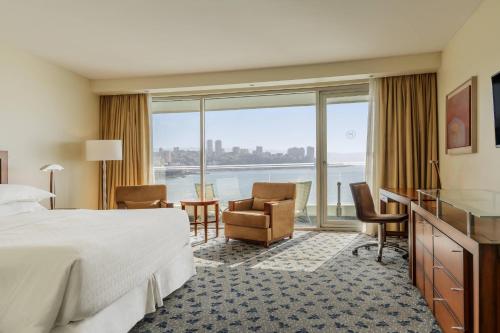um quarto de hotel com uma cama e vista para a água em Sheraton Miramar Hotel & Convention Center em Viña del Mar