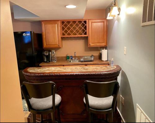 a kitchen with a bar with two chairs at Van Gogh Guest Rm#6 • Van Gogh 6- Private BSMT Rm in single family home in Rosedale