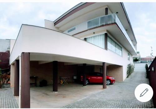 a house with a car parked in front of it at Pousada Floresta in Joinville