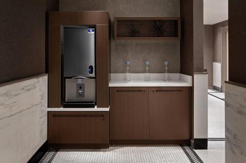 a bathroom with a drink dispenser with two drinking glasses at AC Hotel by Marriott Little Rock Downtown in Little Rock