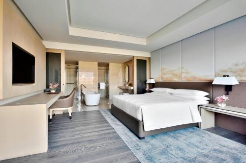 a hotel room with a bed and a bathroom at Indore Marriott Hotel in Indore