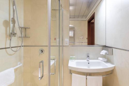 a bathroom with a sink and a shower at Courtyard by Marriott Venice Airport in Tessera