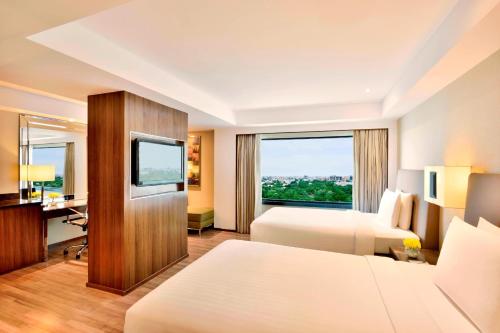 um quarto de hotel com duas camas e uma janela em Courtyard by Marriott Chennai em Chennai
