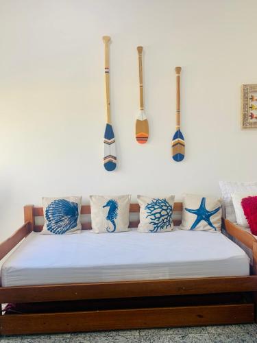 a bed with blue pillows and guitars on the wall at Flet vista mar 1 in Arraial do Cabo