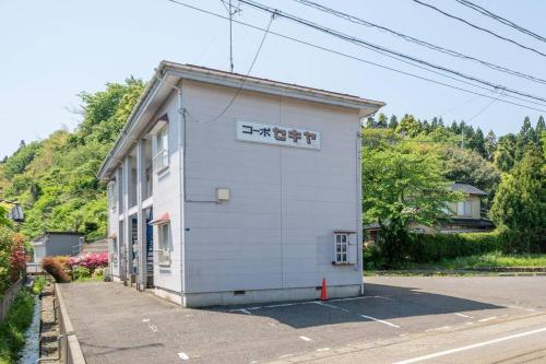 a white building with a sign on the side of it at コーポセキヤ / Corp Sekiya in Itoigawa