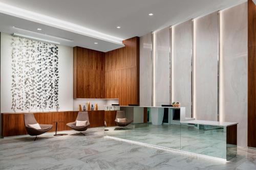 a lobby with a glass table and chairs at AC Hotel by Marriott San Francisco Airport/Oyster Point Waterfront in South San Francisco