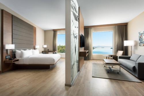 a hotel room with a bed and a living room at AC Hotel by Marriott San Francisco Airport/Oyster Point Waterfront in South San Francisco