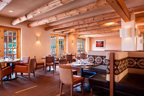 ページにあるコートヤード ペイジ アット レイク パウエルの木製の天井、テーブルと椅子のあるレストラン