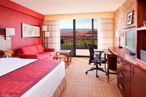 una camera d'albergo con letto, scrivania e TV di Courtyard Page at Lake Powell a Page