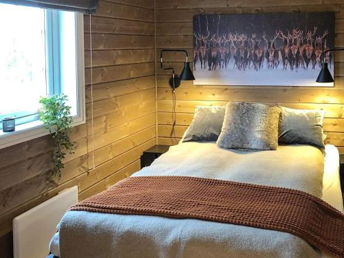 una camera da letto con un letto e un dipinto sul muro di Holiday home Osen II a Vika