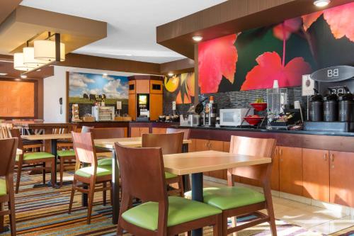 a restaurant with tables and chairs and a bar at AmericInn by Wyndham St Cloud MN Shopping Area in Saint Cloud