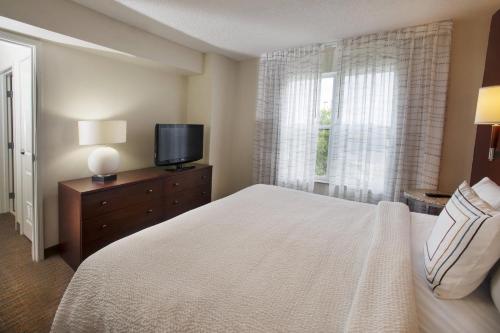a bedroom with a white bed and a television at Residence Inn Paducah in Paducah