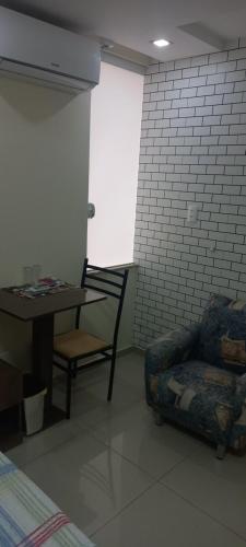 sala de estar con sofá, mesa y silla en Pousada Floresta en Joinville