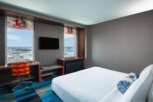 Habitación de hotel con cama, escritorio y ventana en Aloft Boston Seaport District, en Boston