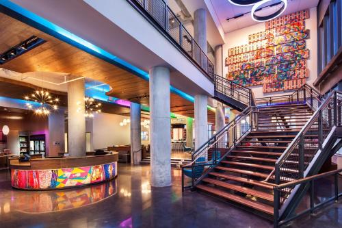 a lobby with stairs and a mural on the wall at Aloft Boston Seaport District in Boston