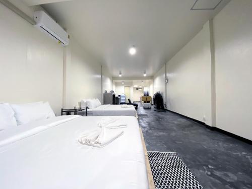 清邁的住宿－Studio townhouse near Airport and old town Chiang Mai，带3张白色床单的床的房间