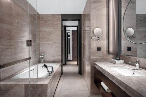 a bathroom with two sinks and a walk in shower at Courtyard by Marriott Suzhou Mudu in Suzhou