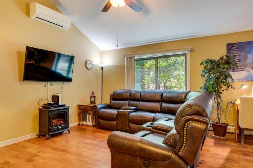 a living room with a leather couch and a television at Bartlett Townhome with Balcony 1 Mi to Ski Resort! in Bartlett
