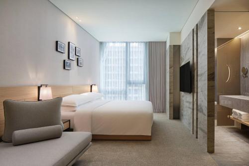 a hotel room with a bed and a couch at Four Points by Sheraton Linkou in Linkou