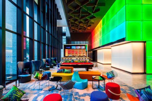 a lobby with colorful chairs and tables in a building at Aloft Taipei Beitou in Taipei