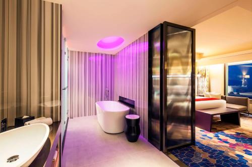 a bathroom with a tub and a toilet and a sink at Aloft Taipei Beitou in Taipei