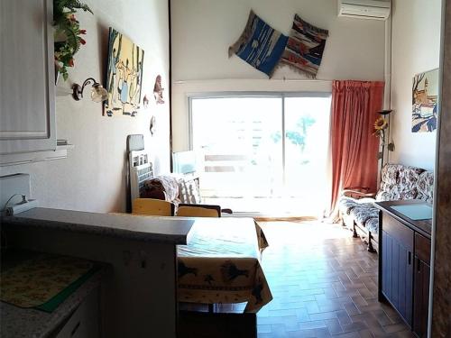 un salon avec un lit et une grande fenêtre dans l'établissement Appartement climatisé avec piscine, parking - Argelès-sur-Mer - FR-1-388-48, à Argelès-sur-Mer