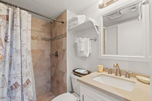 a bathroom with a sink and a toilet and a mirror at Cozy & Charming Oceanfront Condo #803 @ Buena Vista in Myrtle Beach