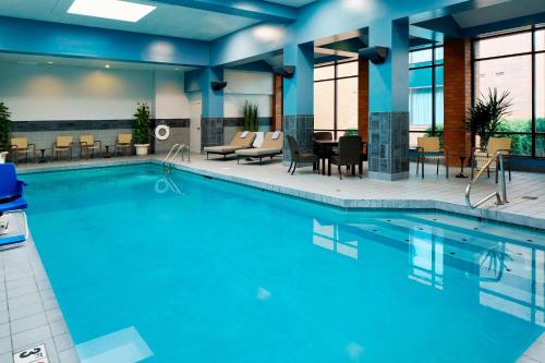 a swimming pool in a hotel with tables and chairs at Marriott Columbus Northwest in Dublin