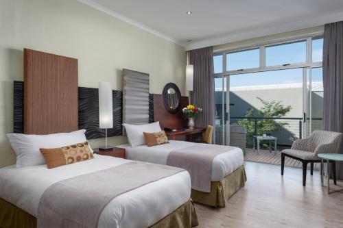 a hotel room with two beds and a balcony at Protea Hotel by Marriott Upington in Upington