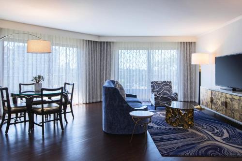 a living room with a table and a dining room at Avenue of the Arts Costa Mesa, a Tribute Portfolio Hotel in Costa Mesa